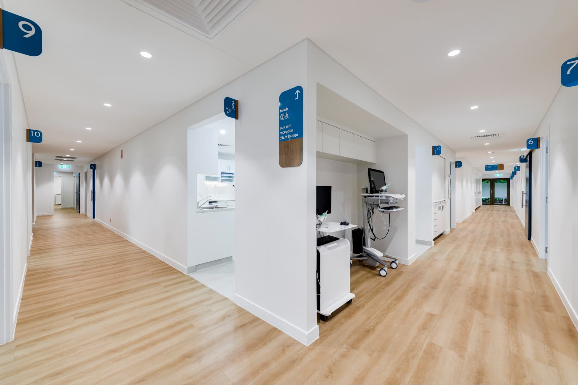 Bright regional healthcare facility corridor with timber doors